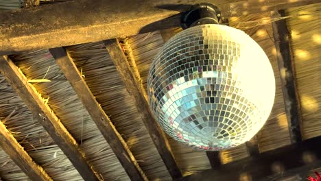 spinning disco ball under wooden ceiling beams