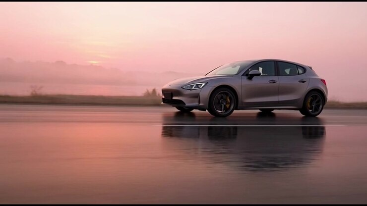 Silver Electric Car Driving on Wet Road at Sunrise