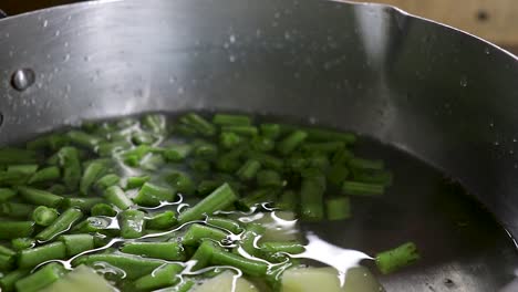 Primer-Plano-De-Patatas-Y-Trozos-De-Judías-Verdes-Puestos-En-Una-Olla-Con-Agua