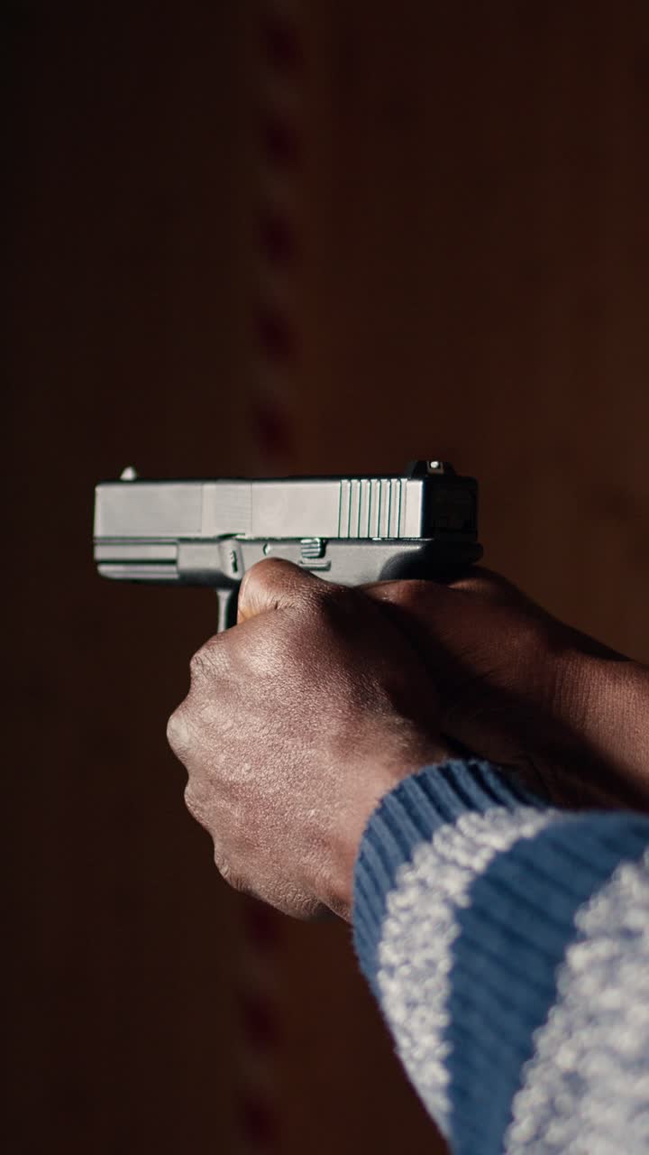 Vertical video Shooting gallery client using handgun to hit paper targets with ammo, close up