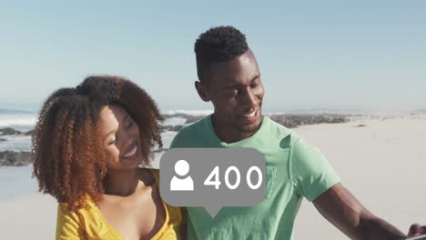 iconos de perfil con números crecientes contra una pareja afroamericana tomando una selfie en la playa