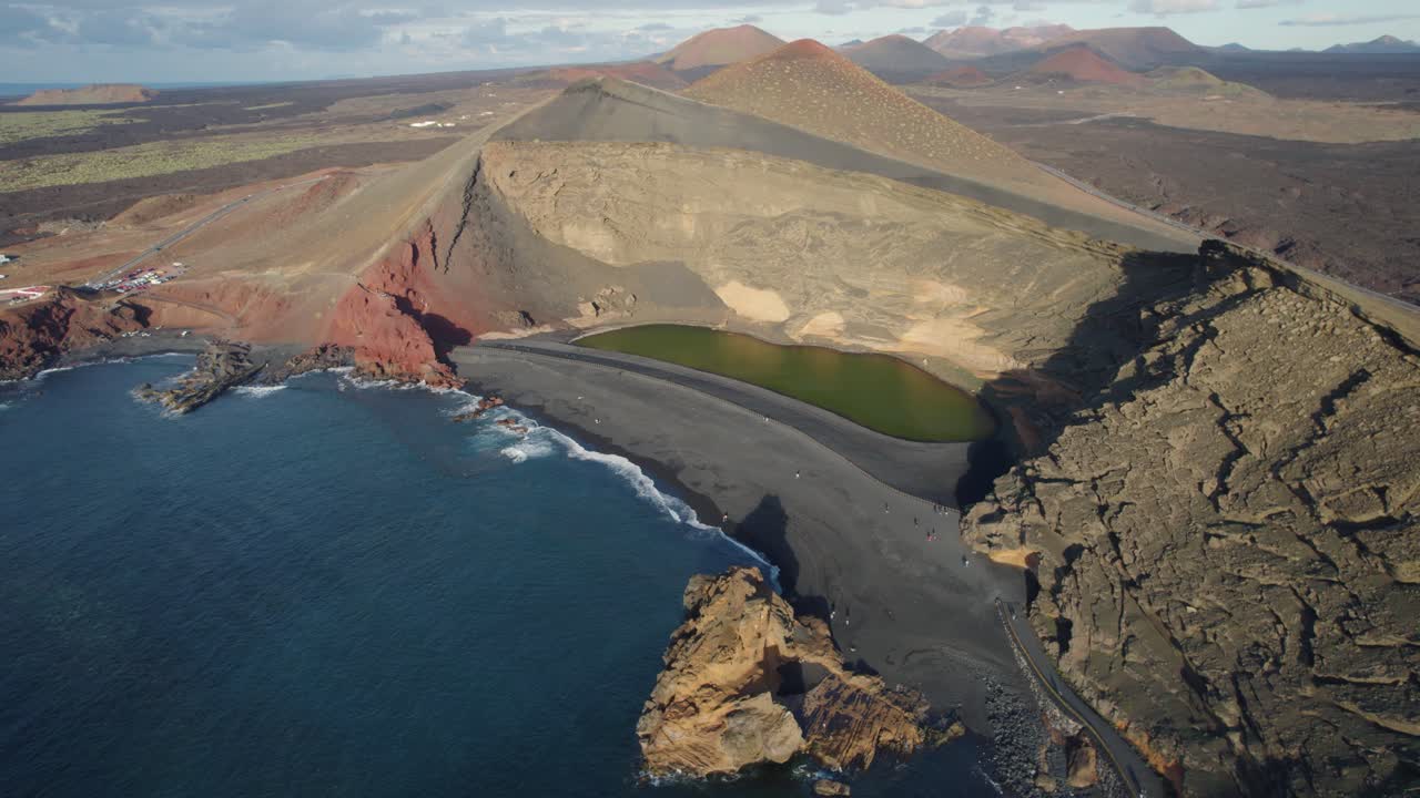 검은 모래 해변이 있는 바다의 만 위로 드론 비행