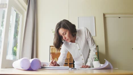 arquitecta caucásica diseñadora de interiores dibujando trabajando desde casa