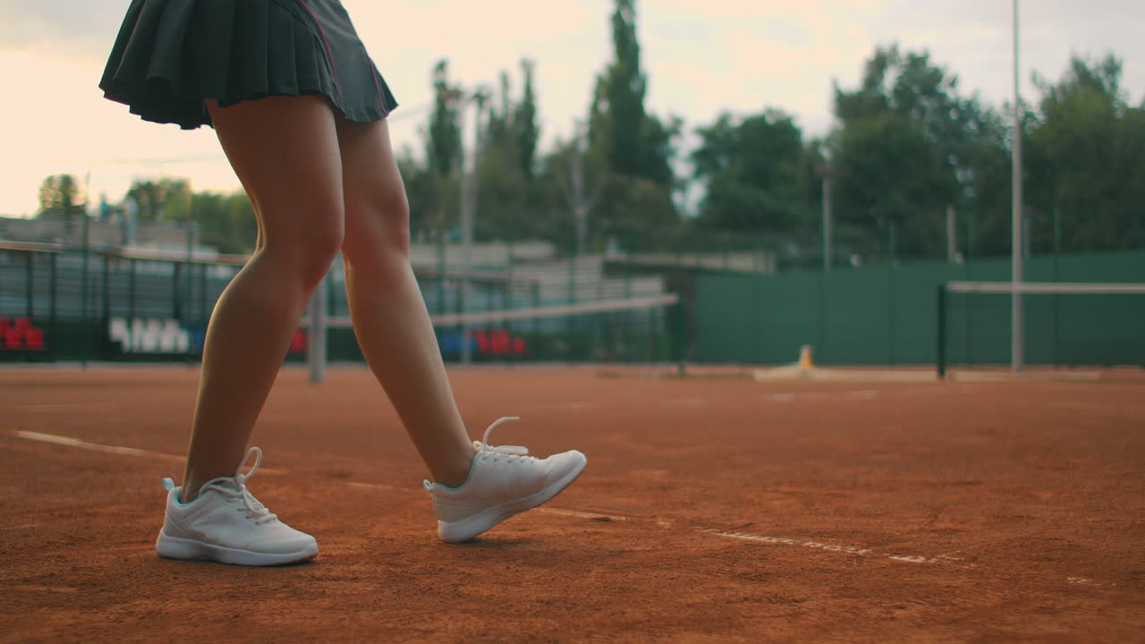 cámara lenta de cerca: joven adolescente caucásica jugadora de tenis sirviendo durante un juego o práctica. jugadora de tenis sirviendo en la cancha de arcilla.