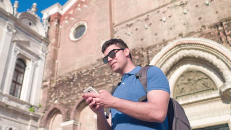 tourist using phone in front of a historical building