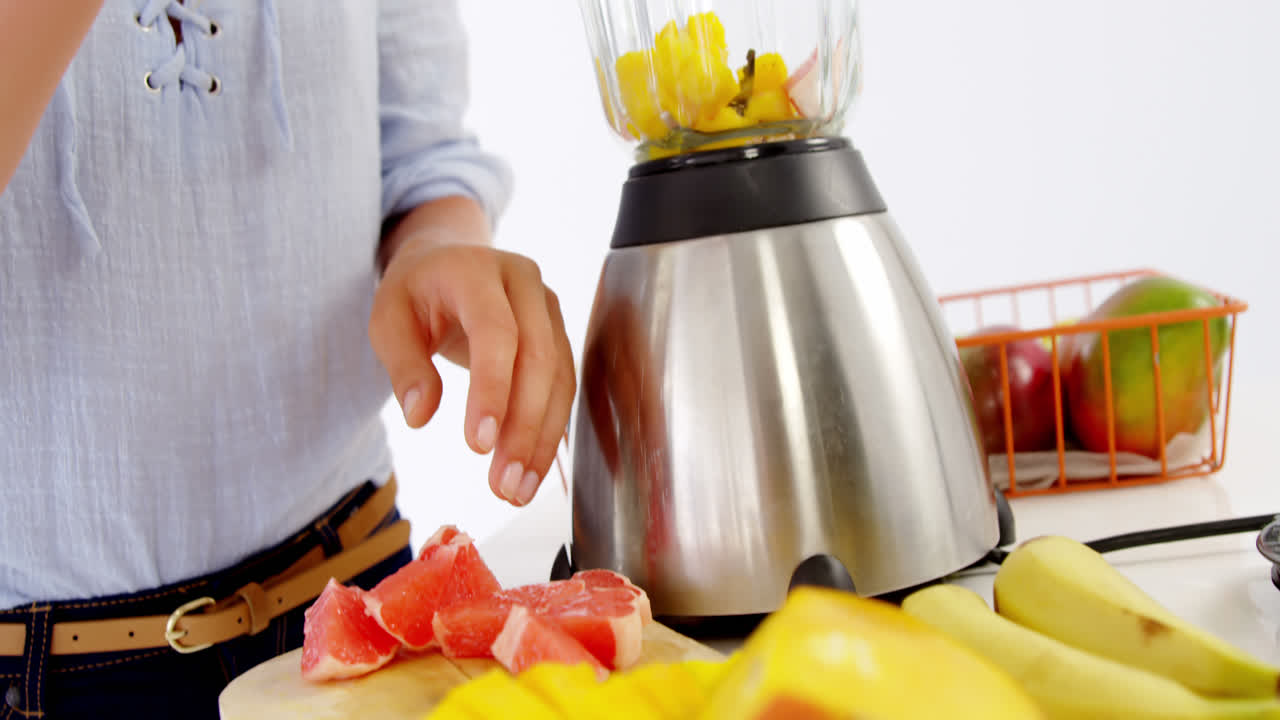 seção média de mulher preparando smoothie