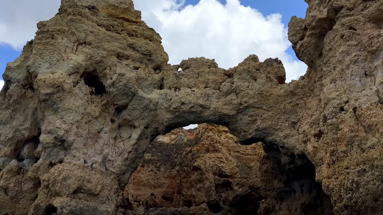 하늘의 구름에 대항하여 알가르베에서 다른 동굴과 정상과 함께 바닥에서  ⁇ 힌 모래석 절벽 형성 - 배에서 내려다보는 경향