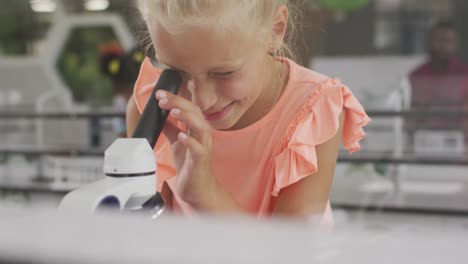 video of happy caucasian girl with microscope during lesson