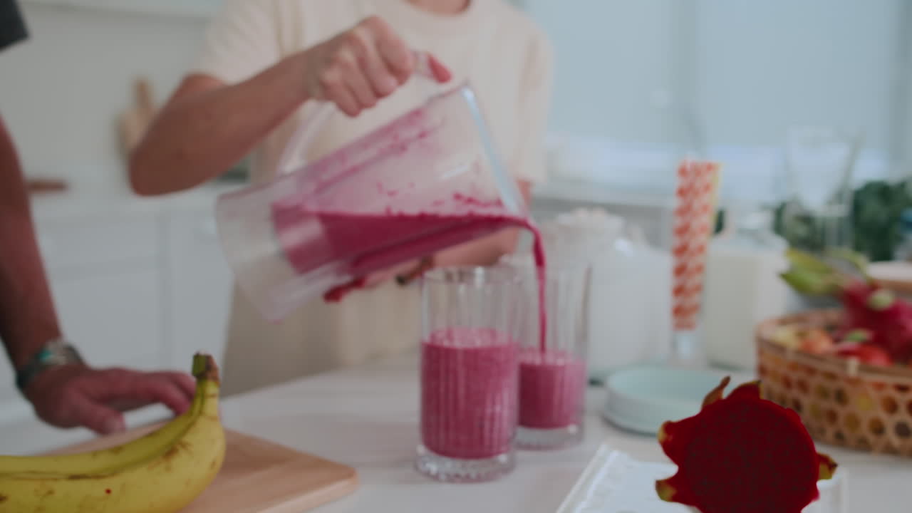 Hands of Person Adding Smoothie to Cups during Breakfast