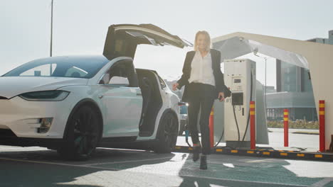 mujer bailando en la estación de carga de coches eléctricos