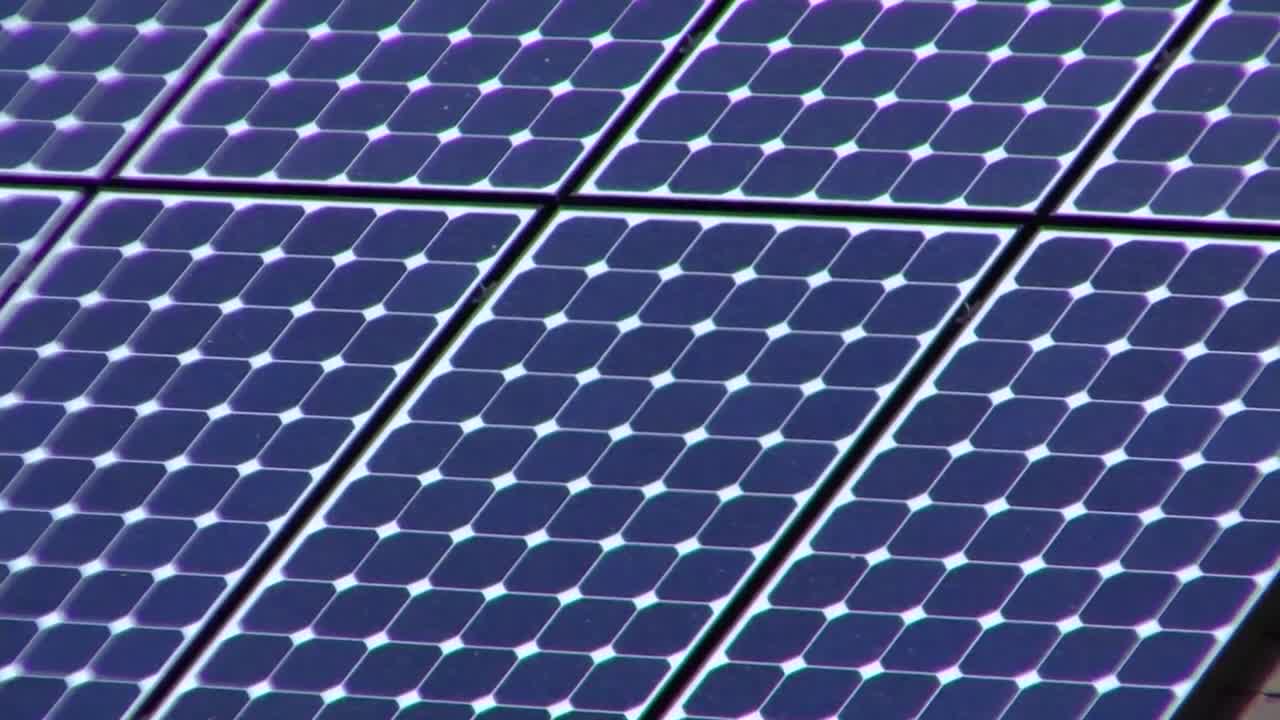 Premium stock video - Zoom out from solar panels adorning the tops of a ...