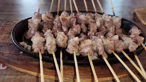 satay de cabra recién cocinado en una placa caliente, vista de cerca