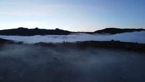 aerial view of a beautiful mountain valley covered with fog and clouds after sunset