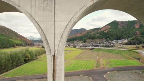un avión no tripulado vuela cerca del puente de cemento geométrico en la carretera rural japonesa, en asago hyogo, aldea rural de japón, sensación agrícola