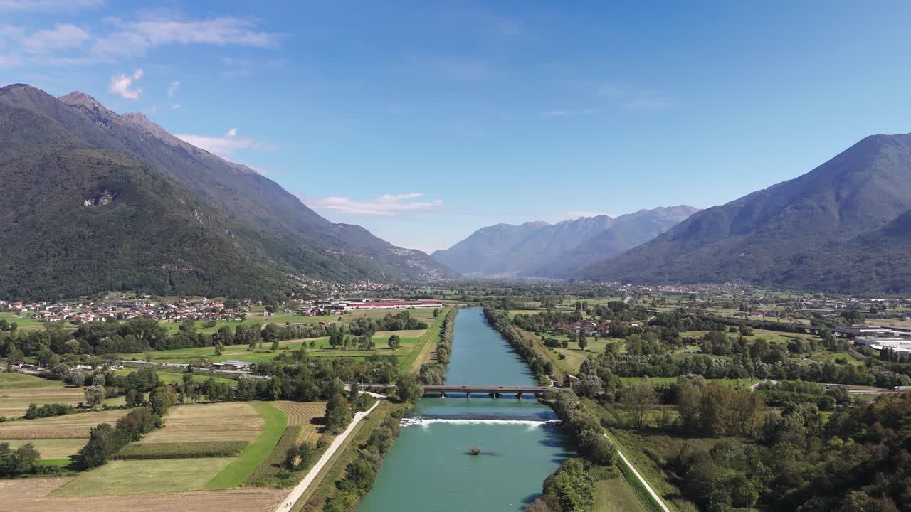 Fly over river towards bridge in Italy