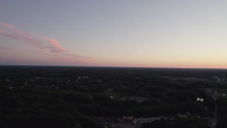 drone dolly motion at dusk with silhouette over small village