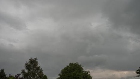 time lapse of fast moving urban storm clouds and rain falls from the dark stormy clouds