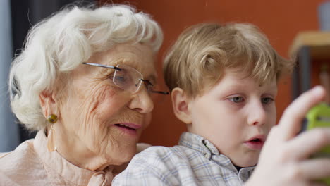 boy playing on gaming console with grandma