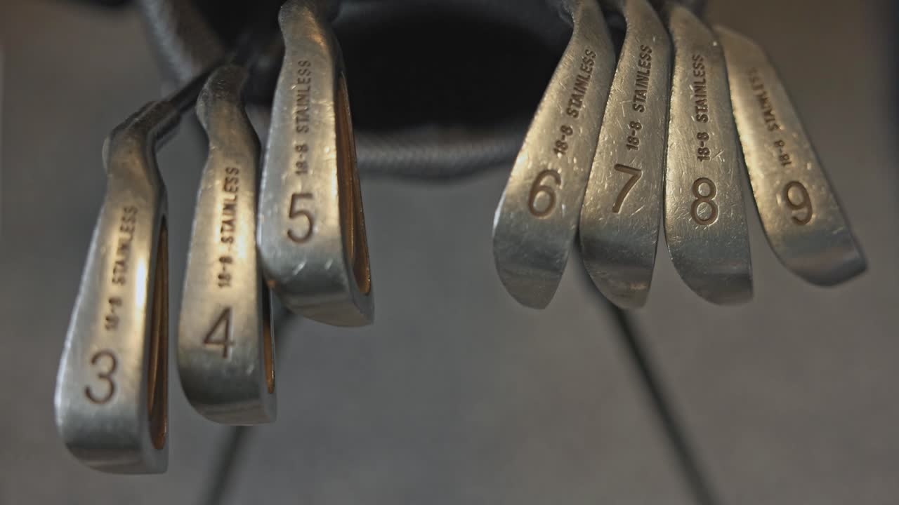 wide-angle shot of ordered golf irons within a golf bag