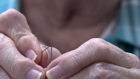 Older-woman-making-several-attempts-at-threading-a-needle