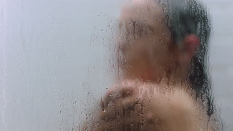 mujer atractiva tomando una ducha tocando la piel húmeda disfrutando de un spa de lujo limpiando el cutis suave