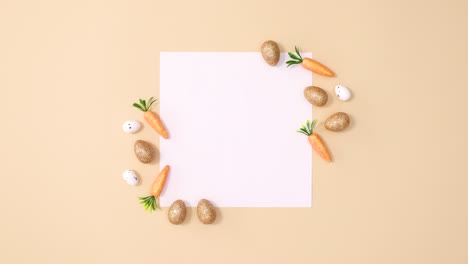 golden glitter easter eggs appear around paper card note on nude background. stop motion minimal flat lay