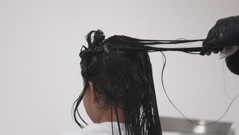 teenage girl gets hair treated with hydration product at minimalist modern beauty salon