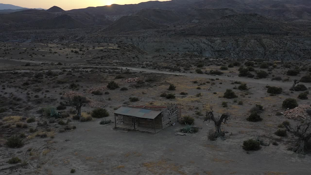 cabaña de madera en el desierto de tabernas al atardecer con dron, almería, españa