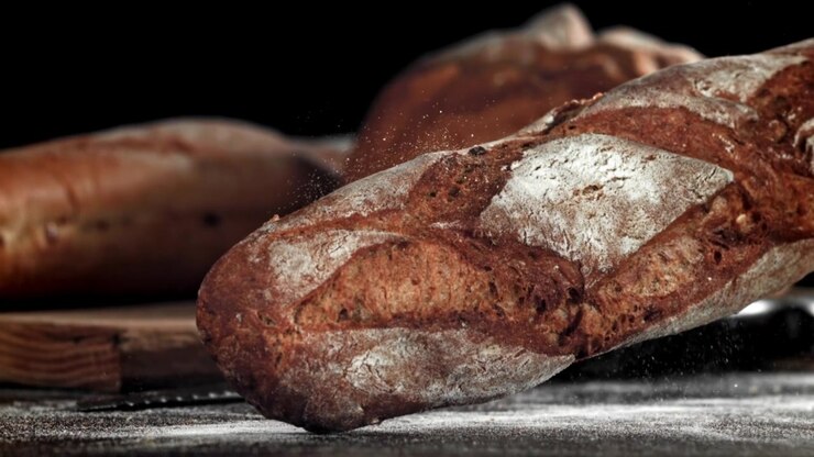 Freshly Baked Baguette Falling onto Flour-Dusted Surface in Slow Motion