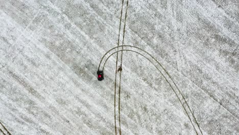 Top-down-view-of-a-ATV-riding-in-a-Snowy-Field---Aerial-View