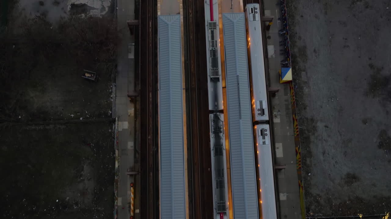 Aerial view above trains at the 125th Street railway station, gloomy evening in Harlem, NY, USA - top down, drone shot
