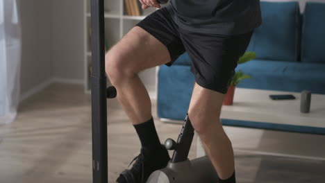 home-fitness-with-stationary-bicycle-middle-aged-man-is-dressed-sportswear-training-on-exercise-bike-at-home-keeping-fit-and-losing-weight-healthy-lifestyle