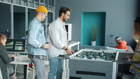 coworkers playing foosball in modern office