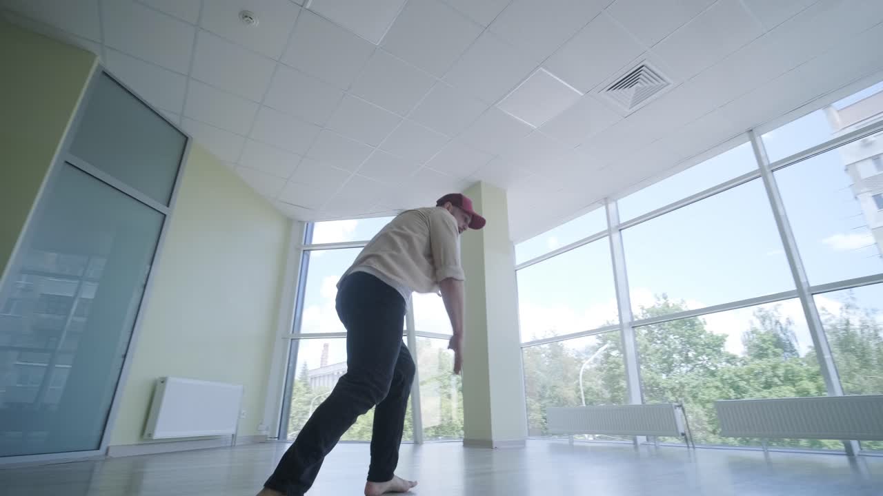 Uomo che balla breakdance in uno studio moderno