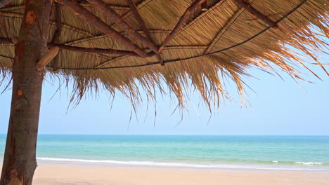 Una-Sombrilla-De-Playa-Tejida-Sombrea-La-Vista-De-Las-Olas-Del-Océano