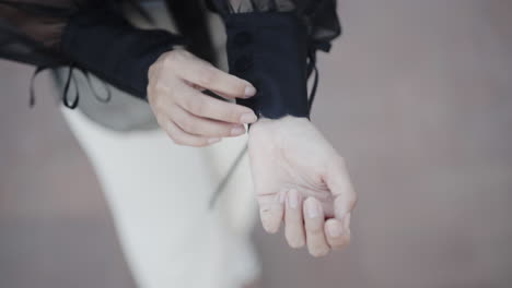 그녀의 공식 셔츠 핸드 헬드 근접 촬영의 마지막 단추를 묶는 패셔니 스타