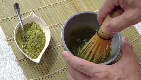 whisking matcha with bamboo whisk