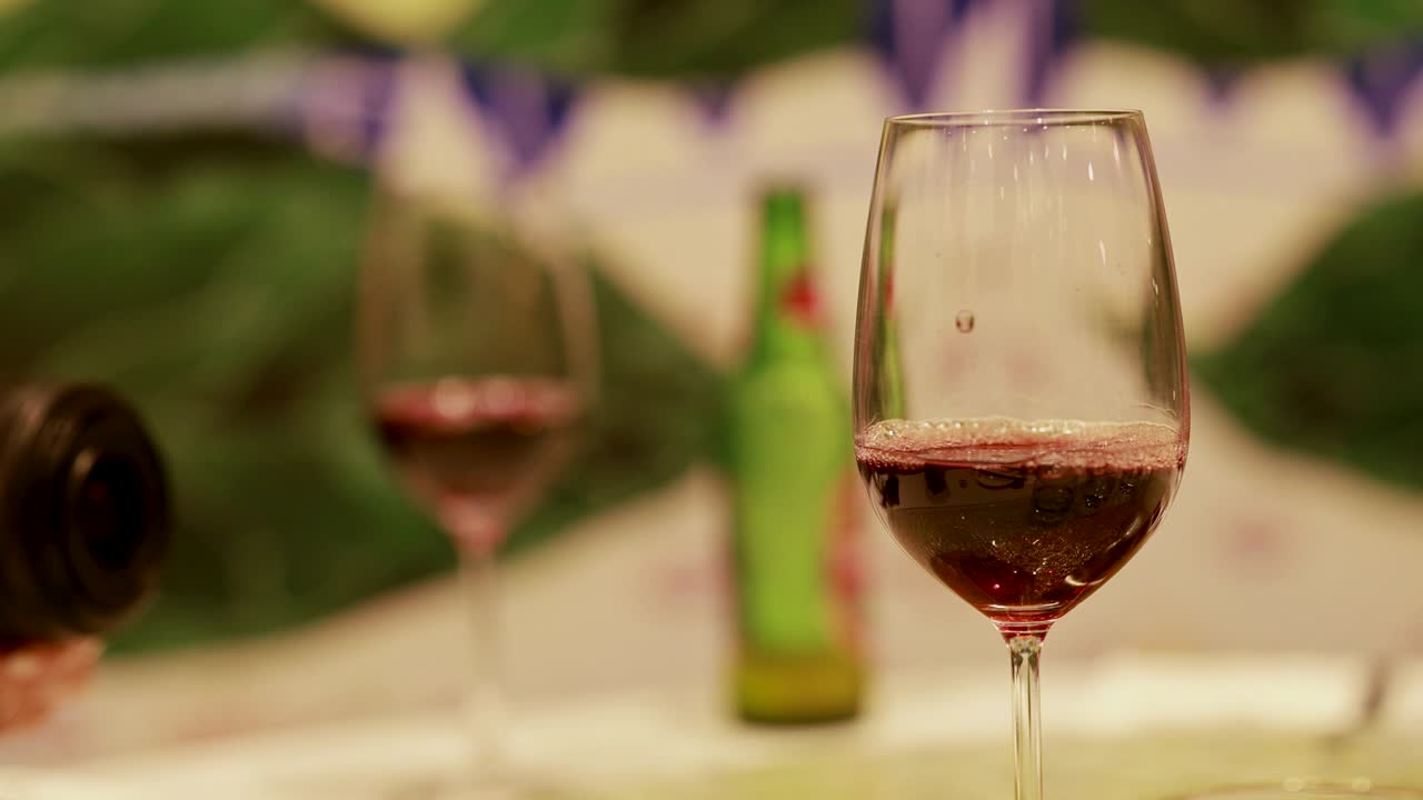 A sequence of pouring red wine into a glass, highlighting fine dining ambiance with soft lighting and close-up focus