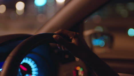 Mujer-Conduciendo-Un-Automóvil-Con-Las-Manos-En-El-Volante-En-La-Ciudad-Por-La-Noche-Viajando-Por-La-Carretera-Hacia-El-Destino