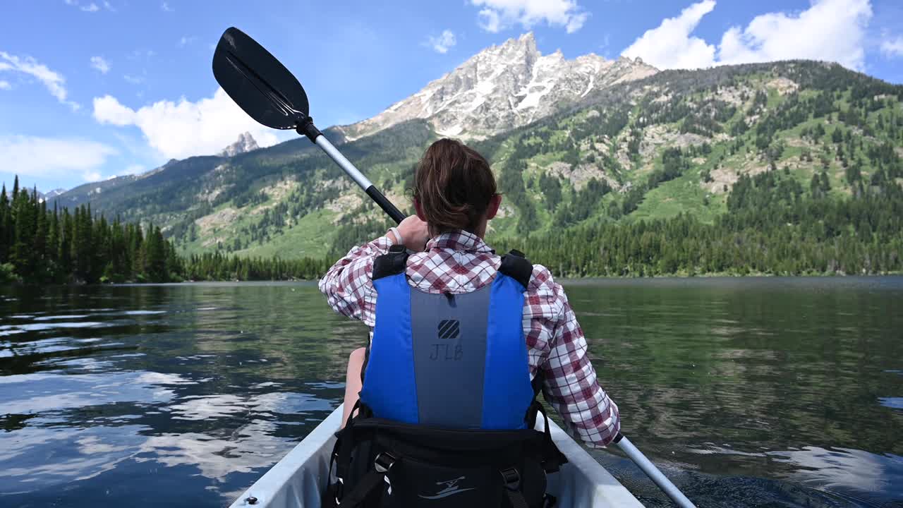 Una donna fa kayak sotto le Grand Tetons