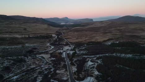 winding road in skye with light snow, during twilight, aerial view