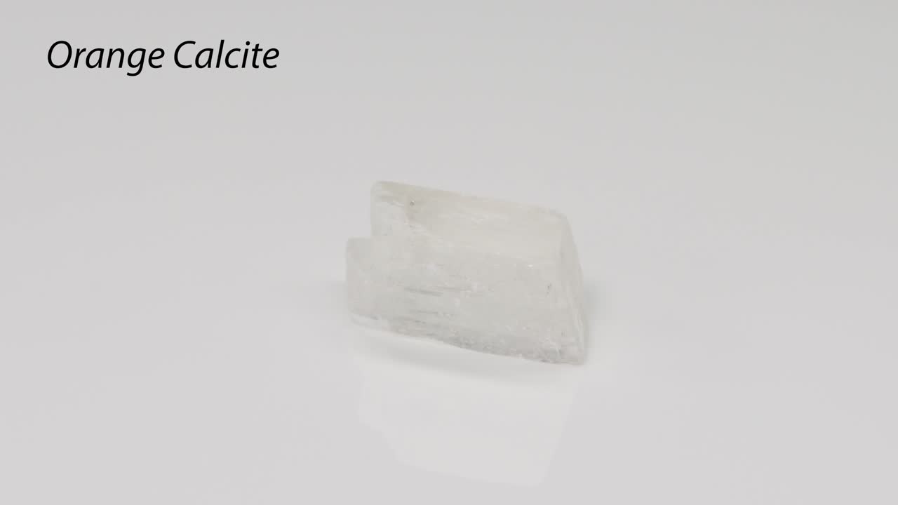 오렌지색 백색 배경에 회전하는 칼시트 결정