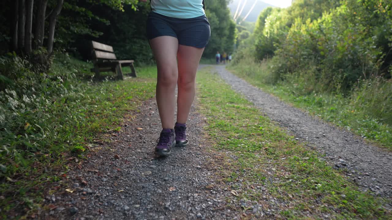 Mulher caminhando em uma trilha em uma floresta