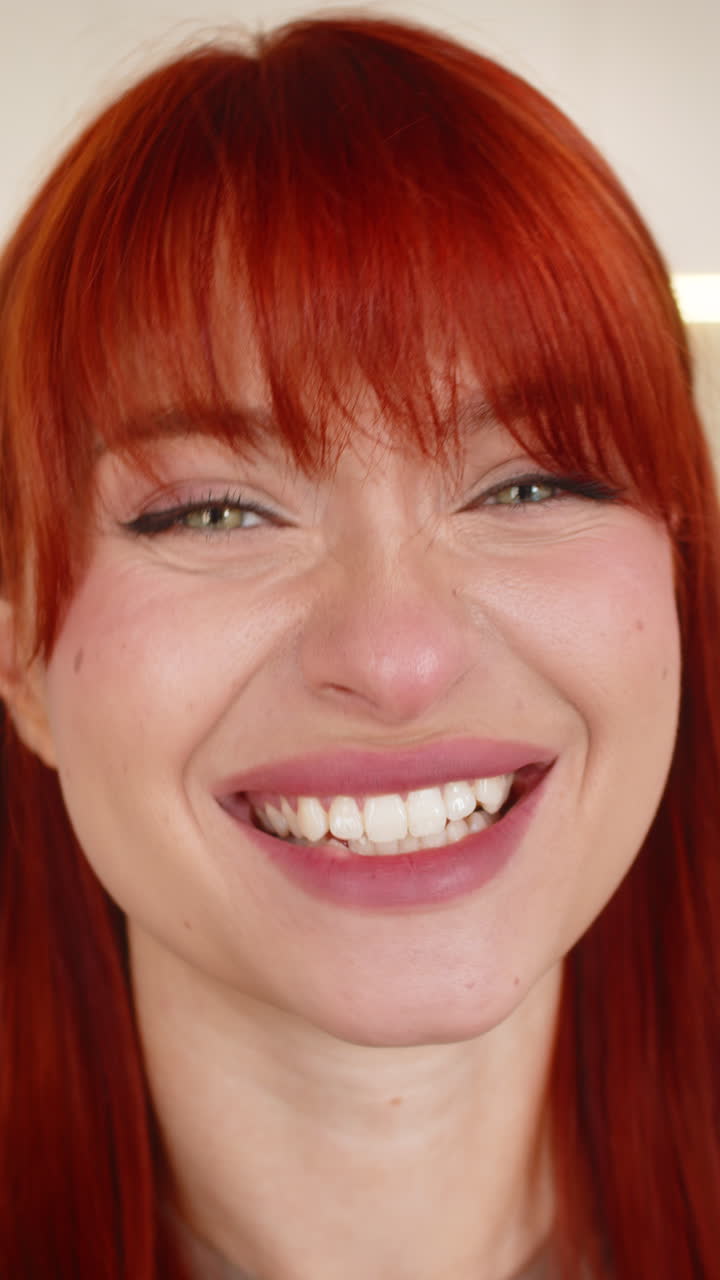 Young woman holds smartphone to camera greets with hello warm wave pov talk video call gentle smile