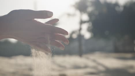 Hands-of-hispanic-woman-playing-with-sand-on-sunny-beach,-slow-motion