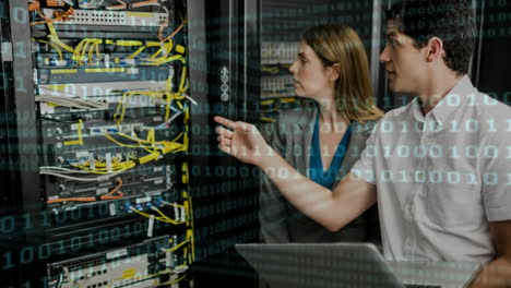 binary code over it professionals managing server racks in data center