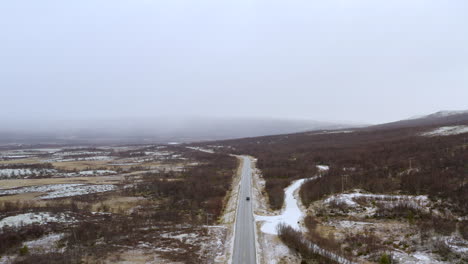 aerial view of country road with foggy mountains in background in dovre, norway