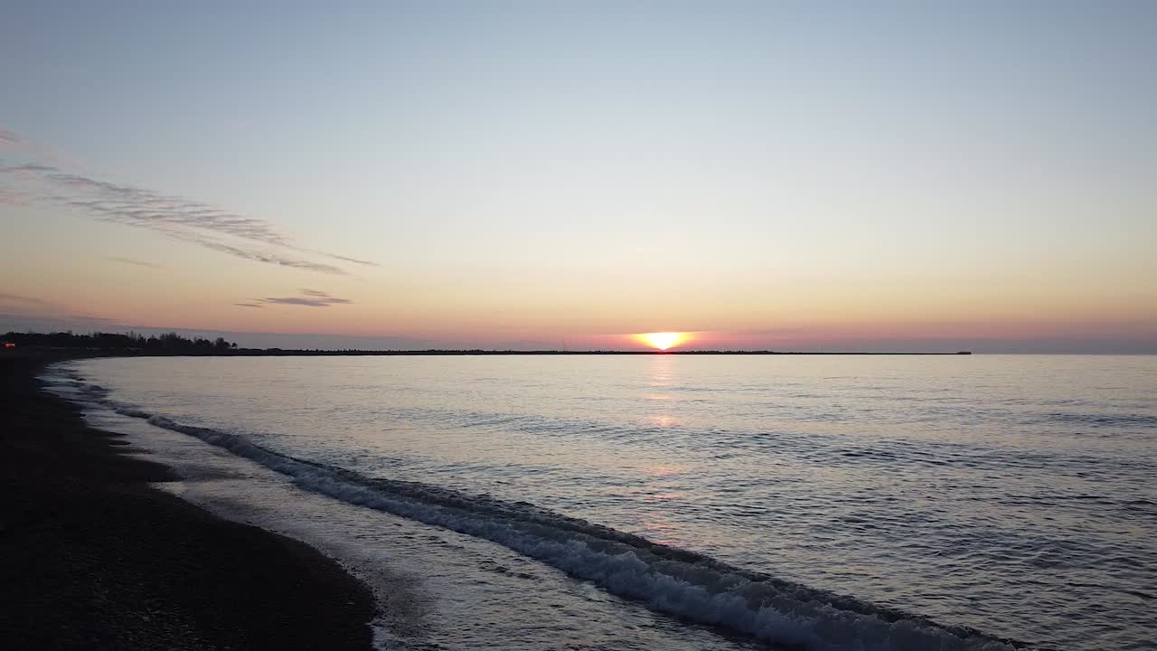 Beautiful vibrant high contrast sunset flyove over the Baltic sea at Liepaja Karosta war port Northern pier, wide angle establishing drone shot moving backwards