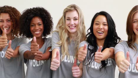 happy female volunteers showing thumbs up