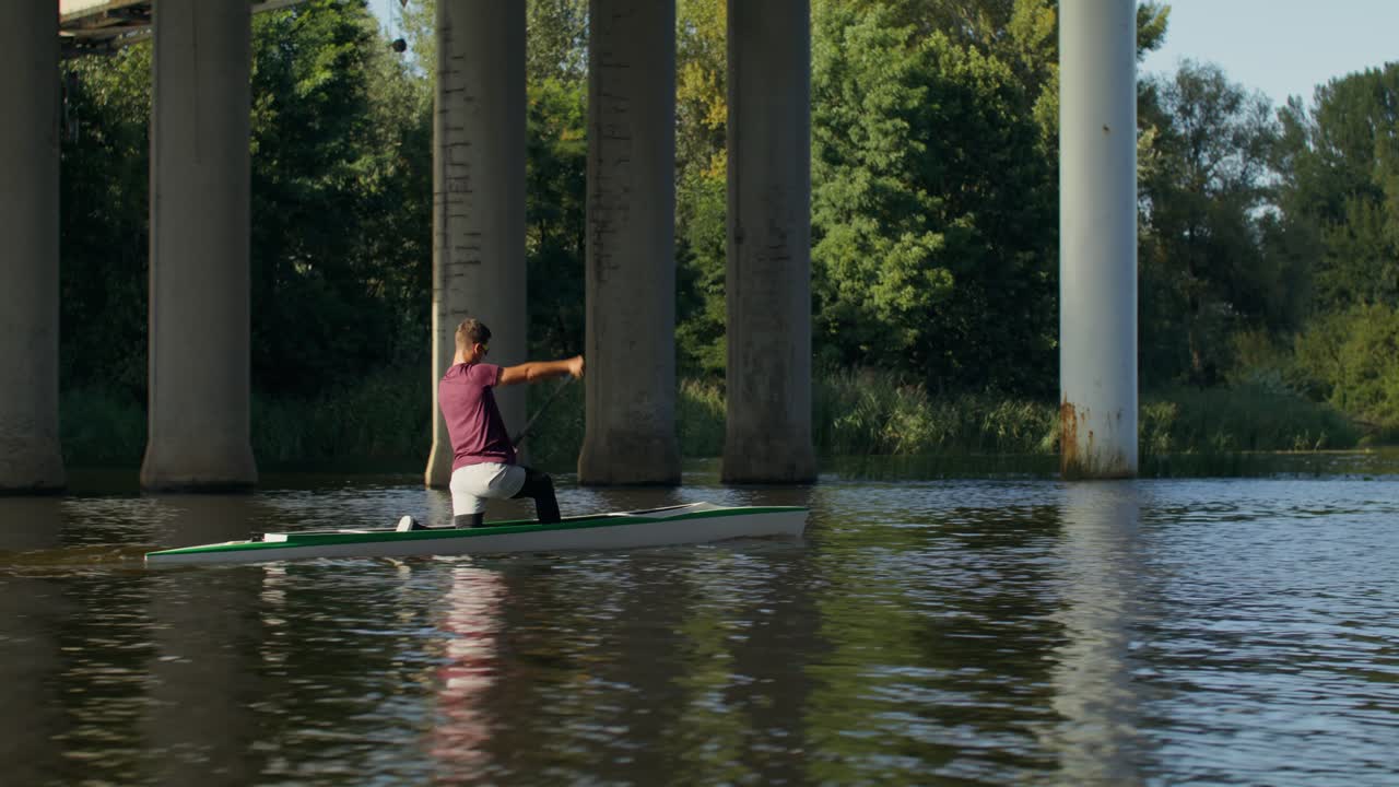 Uomo in canoa sotto un ponte